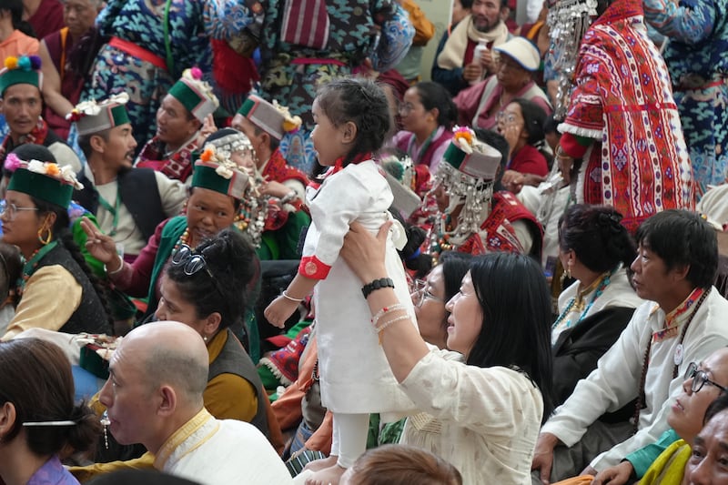 A child is lifted higher to see the stage during celebrations on the 90th birthday of the Dalai Lama at the Main Temple in Dharamsala, India, July 6, 2025.