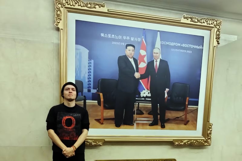 On Feb. 20, 2025, Pierre-emile Biot stands beside a photo from the summit between North Korean leader Kim Jong Un and Russian President Vladimir Putin, at the Choro-Russia Friendship Pavilion in Rason, North Korea.